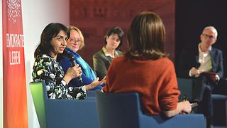 Landtagspräsidentin Aras spricht, die anderen Podiumsteilnehmer hören ihr zu