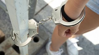 Die Diebin wird mit Handschellen gefesselt.