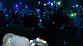 Mit bunten Handylichtern stimmt das Publikum in einer Umfrage ab.