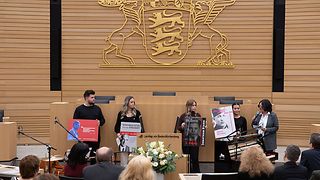 Schüler halten im Plenarsaal Plakate hoch