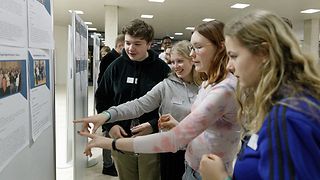 Jugendliche betrachten Stellwände im Foyer des Landtags