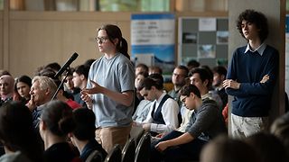 Eine Schülerin stellt eine Frage an das Podium