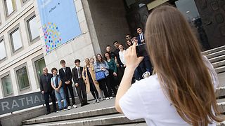 Jugendliche machen ein Foto vor dem Rathaus bei der Stadtrallye