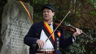 Olaf Creutzburg spielt auf der Geige am Gedenkstein.