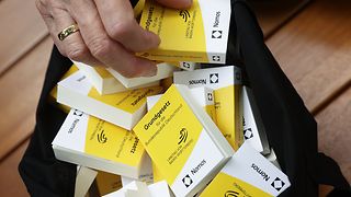 Hand greift in Tasche mit Grundgesetzen im Miniaturformat