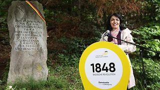 Muhterem Aras am Rednerpult vor Gedenkstein