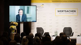 Dr. Frank Bräutigam ist über einen Bildschirm digital zugeschalten