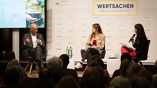 Prof. Dr. Claudius Marx, Isabelle Lindenfelser und Nicole Köster sitzen auf dem Podium