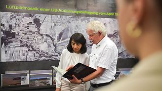 Aras wird etwas in einem Buch gezeigt im Dokumentationszentrum der KZ-Gedenkstätte Hailfingen-Tailfingen