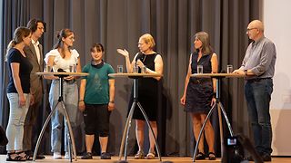 Die Jugendguides diskutieren auf der Bühne mit Prof. Dr. Wolfgang Sannwald, Kreisarchivar des Landkreises Tübingen, und Dr. Ines Mayer von der KZ-Gedenkstätte Bisingen