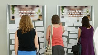 Gäste vor einer Stellwand