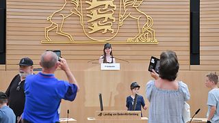 Ein Mädchen wird auf dem Platz der Präsidentin im Plenarsaal fotografiert.