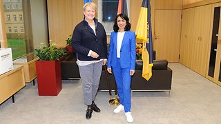 Dr. Cornelia Ruppert, Präsidentin des Rechnungshofs, mit Landtagspräsidentin Muhterem Aras vor Flaggen.