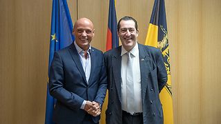 Vizepräsident Born und der französische Generalkonsul stehen vor Flaggen