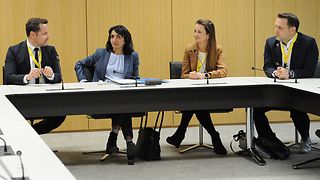 Wirtschaftsjunioren und Landtagspräsidentin sprechen in einem Sitzungssaal miteinander.