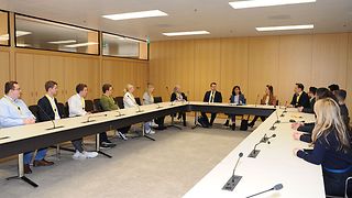 Wirtschaftsjunioren und Landtagspräsidentin sprechen in einem Sitzungssaal miteinander.