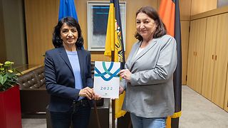 Bürgerbeauftragte Beate Böhlen und Landtagspräsidentin Muhterem Aras halten den Jahresbericht 2022 in der Hand