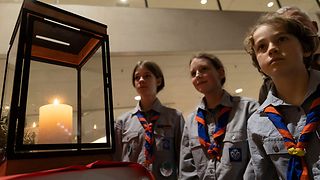 Zwei Pfadfinder:innen vor dem Friedenslicht.