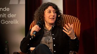 Lena Gorelik sitzt in einem Sessel auf der Bühne und spricht.