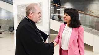 Landtagspräsidentin Aras begrüßt einen Priester