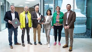 Landtagspräsidentin Aras hält Mappe mit gesammelten Unterschriften des Volksantrags "Ländle leben lassen"