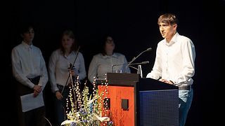 Ein Vertreter der Jüdischen Jugend Baden spricht am Rednerpult, andere stehen im Hintergrund.