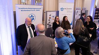 Menschen sprechen am Stand der IRG Baden.