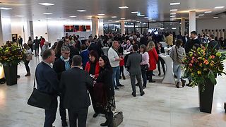 Die Gäste unterhalten sich beim Stehempfang im Foyer.