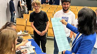 Die Schülerinnen und Schüler zeigen Landtagspräsidentin Aras ihr Wahllokal.