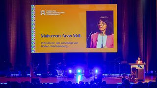 Aras hält eine Rede auf der Bühne