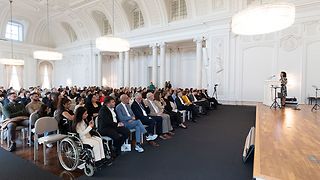 Menschen sitzen im Saal