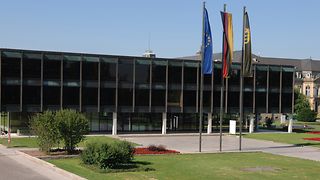 Außenansicht des Landtagsgebäudes mit den Flaggen der Europäischen Union, der Bundesrepublik Deutschland und des Landes Baden-Württemberg