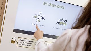 Jugendliche tippt auf einen Monitor