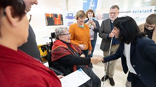 Landtagspräsidentin Muhterem Aras im Gespräch mit einer Frau im Rollstuhl
