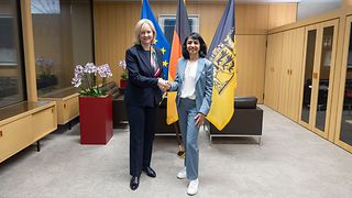 Botschafterin und Landtagspräsidentin vor den Flaggen