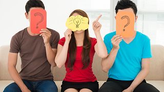 Drei Jugendloche die Fragezeichen vor ihren Gesichtern halten