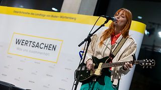 Die Musikerin Alex Mayr mit Gitarre