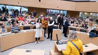 Besucher machen Fotos am Redepult im Plenarsaal