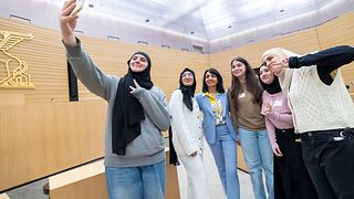 Mädchen machen mit Präsidentin Aras ein Selfie im Plenarsaal