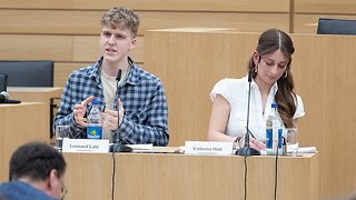 Zwei Jugendliche diskutieren am Rednerpult