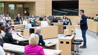 Im Plenarsaal spricht Beiratsvorsitzender Ralf Nentwich über den Wettbewerb.