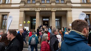 Bürger beim Fest zum Tag der Deutschen Einheit mit Blick auf den Landtag des Saarlandes.