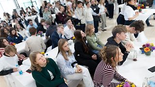 Jugendliche an Tischen und Bänken