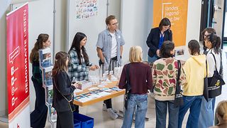 Jugendliche informieren sich an einem Info-Stand