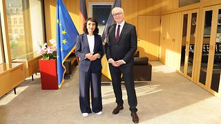 Präsidentin und Botschafter vor den Flaggen