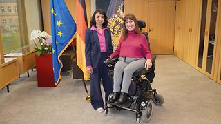 Landtagspräsidentin Muhterem Aras und Landesbehindertenbeauftragte Nora Welsch vor den Flaggen