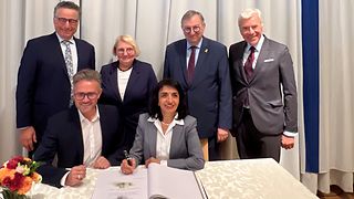 Landtagspräsidentin Aras trägt sich ins goldene Buch der Stadt Pforzheim ein.