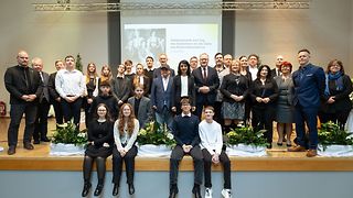 Gruppenbild mit Abgeordneten sowie Schülerinnen und Schülern auf der Bühne