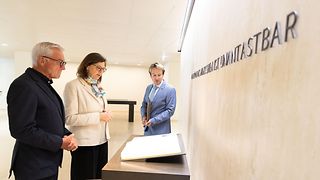 Ilse Aigner betrachtet zusammen mit anderen das Gedenkbuch