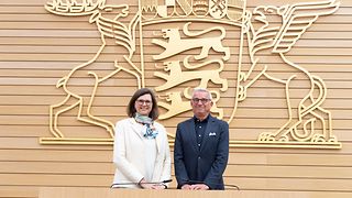 Ilse Aigner und Thomas Strobl posieren vor dem großen Landeswappen im Plenarsaal